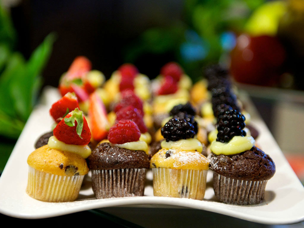 Nell'immagine, un primo piano di alcuni dolcetti alla frutta con la crema poggiati su un vassoio per la colazione del The Hub Hotel a Milano.